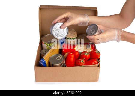 food donations box isolated on white, hands in gloves holding tin can Stock Photo