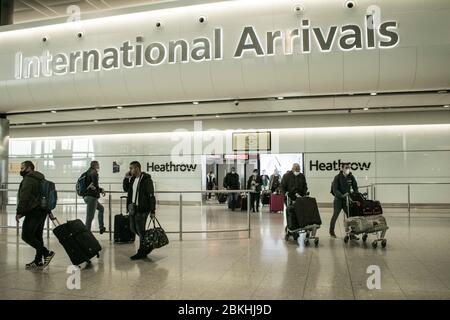 HEATHROW LONDON, 4 May 2020. UK. Passengers wearing surgical masks for protection against covid-19 arrive at Heathrow airport Terminal 2. Heathrow is to introduce  temperature screening of passengers arriving and departing, including Britons returning from abroad. Credit: amer ghazzal/Alamy Live News Stock Photo