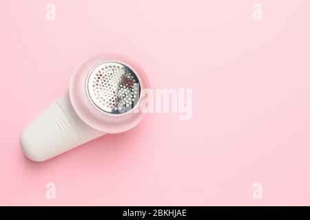 Modern fabric shaver on color background Stock Photo