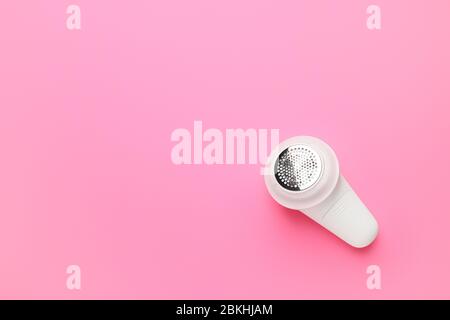 Modern fabric shaver on color background Stock Photo