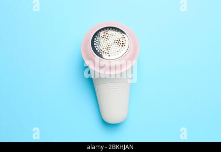 Modern fabric shaver on color background Stock Photo