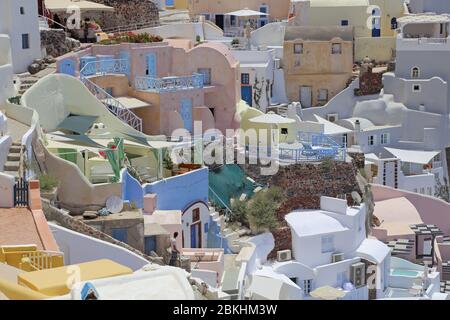 The picturesque and colorful dwellings in the town of Oia, on the Aegean Sea island of Santorini, Greece are shown in a daytime view during summer. Stock Photo