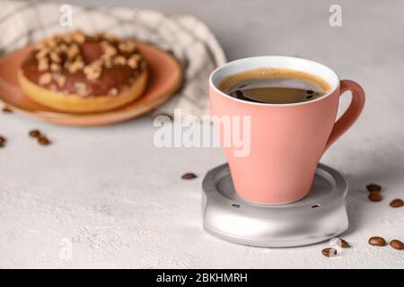 Cup of coffee with heater on table Stock Photo