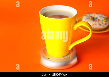 Cup of coffee with heater on color background Stock Photo