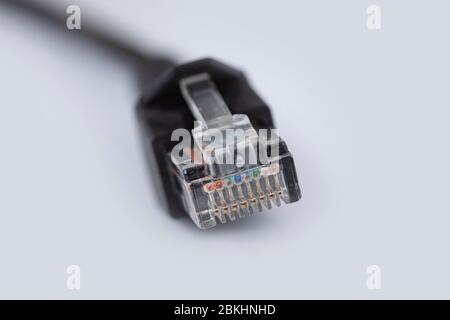 Ethernet cable plug connector. Network connection, internet communication and computer technology close-up view on white background and shallow depth Stock Photo
