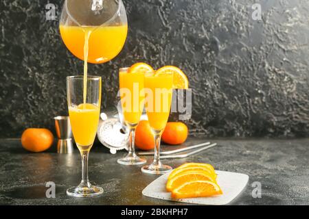 Pouring of orange juice in glass on table Stock Photo