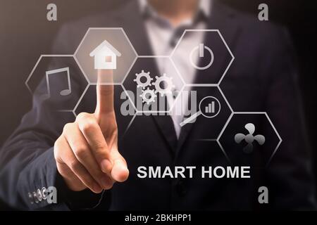 Contemporary technologies. Different smart home icons on virtual screen and man pushing house button, collage Stock Photo