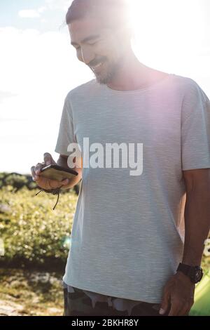 Man checking his smartphone in a sunny day Stock Photo
