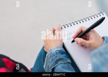 Close up of a young college student taking notes on campus Stock Photo