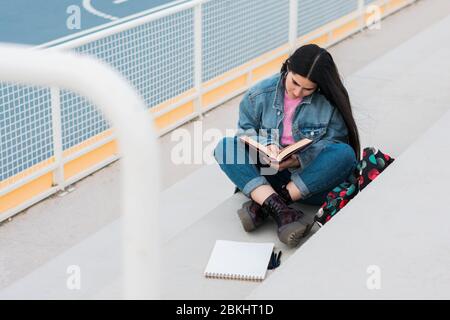 Young university student reads and takes notes on campus Stock Photo