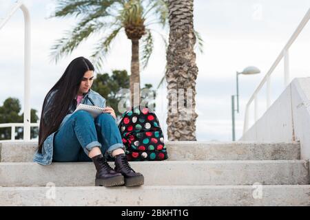 Young college student taking notes on campus outdoor Stock Photo