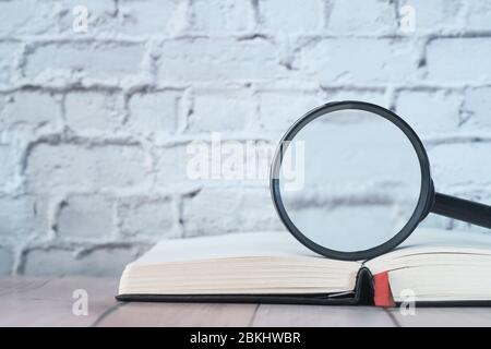 Close up of magnifying glass on book on table  Stock Photo