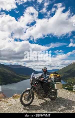 Motorbike rider stops in front of lake on Ruta 3 in Tierra del Fuego Stock Photo