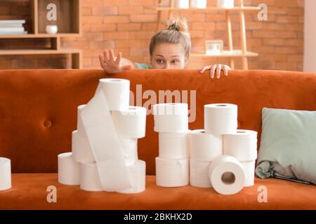 Woman with heap of toilet paper at home. Concept of coronavirus epidemic Stock Photo
