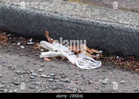 A discarded latex glove lying on the ground Stock Photo