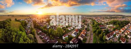 Aerial panorama of a small town at sunrise, with magnificent colorful sky and warm light Stock Photo