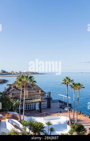 Palm trees at the closed pool and restaurant Las Rocas, part of the Jardin Tropical hotel during the covid 19 lockdown in the tourist resort area of C Stock Photo