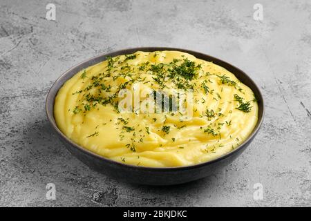 Ceramic plate with mashed potato on abstract concrete background Stock Photo