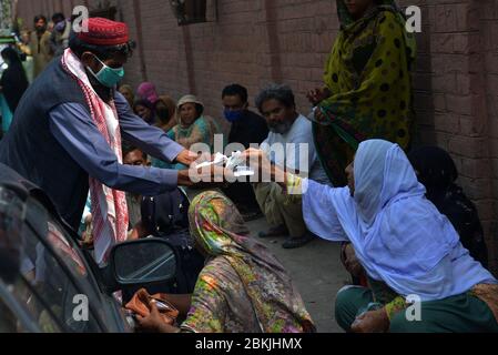 Lahore, Pakistan. 04th May, 2020. A large numbers of deserving poor women sitting on Davis Road side as receiving Zakat during Ramazan-ul-Mubarak in provincial capital city Lahore . Millions of Muslims have started Ramadan, the holiest month on the Islamic calendar, under the coronavirus lockdown or strict social restrictions from government of Pakistan. (Photo by Rana Sajid Hussain/Pacific Press) Credit: Pacific Press Agency/Alamy Live News Stock Photo