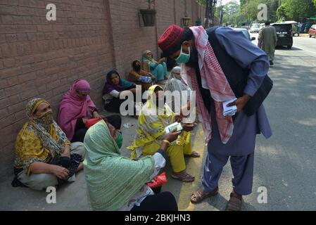 Lahore, Pakistan. 04th May, 2020. A large numbers of deserving poor women sitting on Davis Road side as receiving Zakat during Ramazan-ul-Mubarak in provincial capital city Lahore . Millions of Muslims have started Ramadan, the holiest month on the Islamic calendar, under the coronavirus lockdown or strict social restrictions from government of Pakistan. (Photo by Rana Sajid Hussain/Pacific Press) Credit: Pacific Press Agency/Alamy Live News Stock Photo