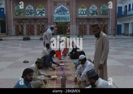 Lahore, Pakistan. 04th May, 2020. Pakistani members of Jamia Naeemia administration offering dua during Iftar as they sit in social distance during Ramazan-ul-Mubarak in provincial capital city Lahore. Millions of Muslims have started Ramadan, the holiest month on the Islamic calendar, under the coronavirus lockdown or strict social restrictions from government of Pakistan. (Photo by Rana Sajid Hussain/Pacific Press/Sipa USA) Credit: Sipa USA/Alamy Live News Stock Photo
