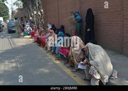 Lahore, Pakistan. 04th May, 2020. A large numbers of deserving poor women sitting on Davis Road side as receiving Zakat during Ramazan-ul-Mubarak in provincial capital city Lahore . Millions of Muslims have started Ramadan, the holiest month on the Islamic calendar, under the coronavirus lockdown or strict social restrictions from government of Pakistan. (Photo by Rana Sajid Hussain/Pacific Press/Sipa USA) Credit: Sipa USA/Alamy Live News Stock Photo