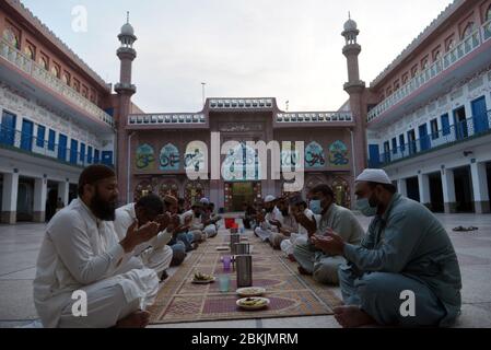 Lahore, Pakistan. 04th May, 2020. Pakistani members of Jamia Naeemia administration offering dua during Iftar as they sit in social distance during Ramazan-ul-Mubarak in provincial capital city Lahore. Millions of Muslims have started Ramadan, the holiest month on the Islamic calendar, under the coronavirus lockdown or strict social restrictions from government of Pakistan. (Photo by Rana Sajid Hussain/Pacific Press/Sipa USA) Credit: Sipa USA/Alamy Live News Stock Photo