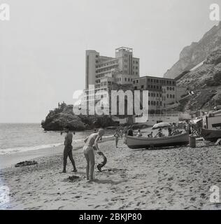1960s, historical, a view of the sandy beach at Catalan Bay and the famous Caleta Palace Hotel, built on a corner of the rocky limestone ridge known as the Rock of Gibraltar. Gibraltar is a British Overseas Territory and headland on the south coast of Spain. Stock Photo