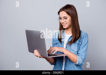 Close-up portrait of her she nice attractive lovely intelligent cheerful focused creative girl working on laptop creating report isolated over grey Stock Photo
