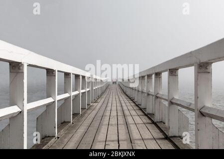 Quiet wharf leading to foggy sea in Finnish spring weather Stock Photo