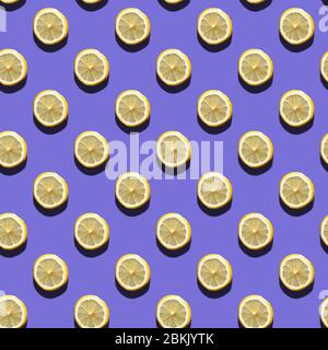 Slices of lemon seamless pattern on purple background, natural sunlight with hard shadows. Healthy eating concept Stock Photo