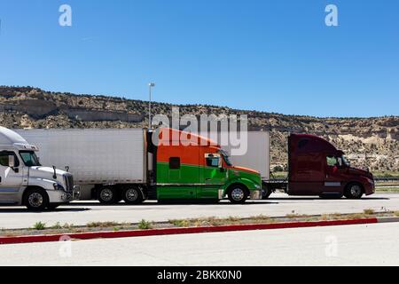 Modern trucks of various colors and models  transportation of different kinds of commercial goods stand in row on truck stop parking lot for truck dri Stock Photo