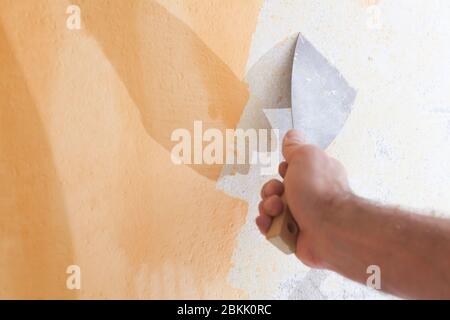 Scraping old plaster and applying new. Reconstruction of a new house. Stock Photo