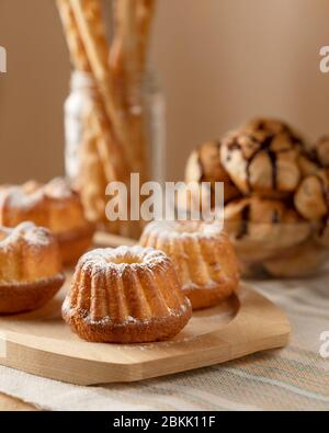 Bakery products for breakfast. Various fresh baked goods, cupcakes or muffins, croissants and bread sticks on the table. Food concept. Stock Photo