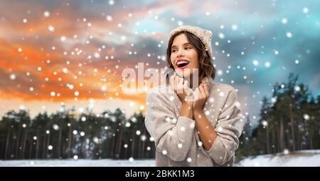 woman in hat and sweater over winter forest Stock Photo