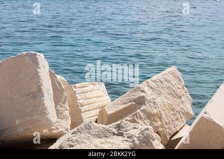 Beautiful big white limestone textured blocks at Bol, Brac, Dalmatia, Croatia and the Adriatic  sea in the background. Famous stones used for stone ma Stock Photo