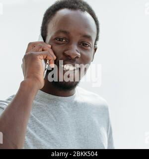 side view. stylish young man talking on his smartphone. Stock Photo