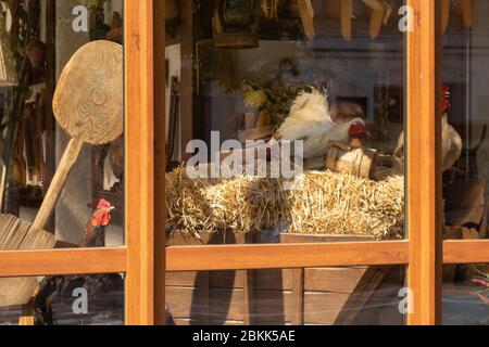 Hens and rooster on a hay in a cart outside the window of a village house. Stock Photo