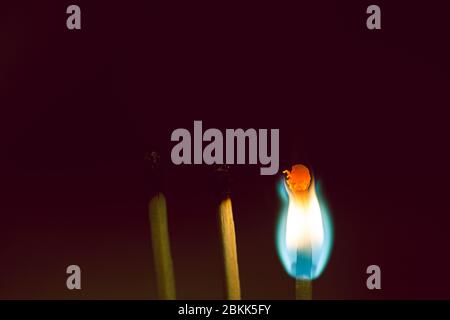 Three match sticks burning isolated on a black background Stock Photo