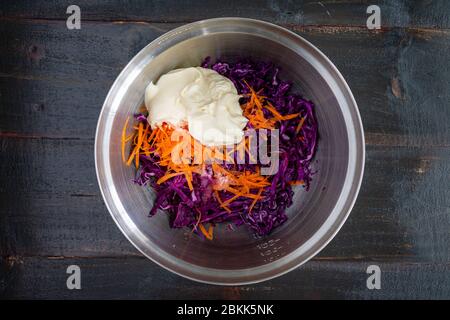 Coleslaw Ingredients in a Mixing Bowl: Mayonnaise, shredded cabbage, carrots, and other slaw ingredients Stock Photo