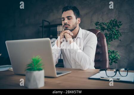 Portrait of his he nice attractive intelligent confident focused man skilled qualified finance expert economist reviewing report at modern loft Stock Photo