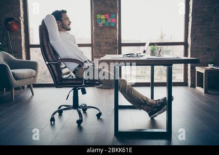 Profile side view of his he nice attractive chic elegant confident cheerful man qualified expert shark sitting in chair having rest at modern loft Stock Photo