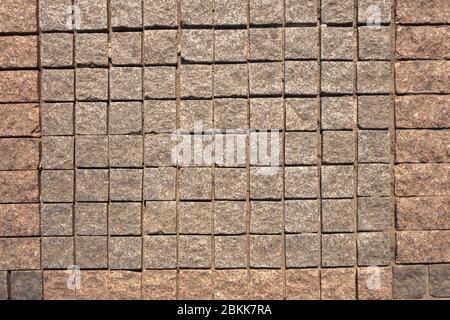 The structure of the pavers is made of granite square elements in gray and red. Stock Photo