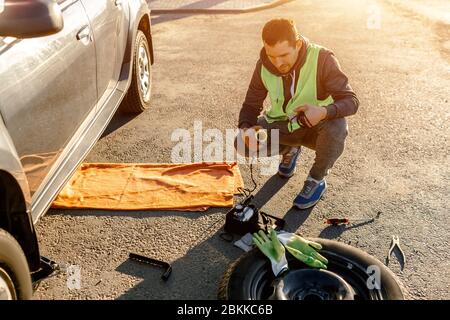 Worker or driver tired of repairing a car on the side of the road Stock Photo