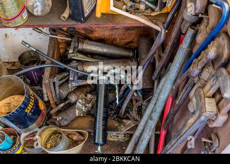 Swift Current, SK/Canada- May 1, 2020: A collection of vintage grease guns, pipe wrenches and various hardware Stock Photo