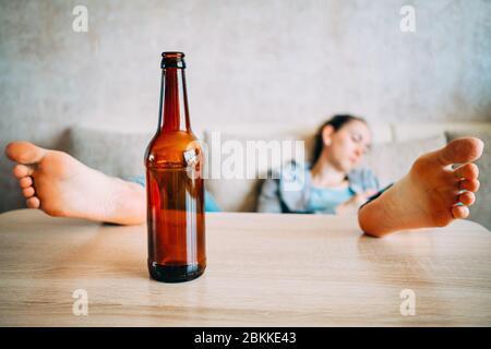 The concept of alcoholism girl sleeps throwing legs on the table. Close up. Stock Photo