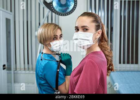 Female doctors young and adult masked snapshot in clinic. Thank you for staying at home. Kovid 19. Vachi in a mask. The fight against the virus. Stock Photo