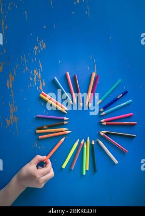 Young Child Picking Up Color Pencil From Set Stock Photo
