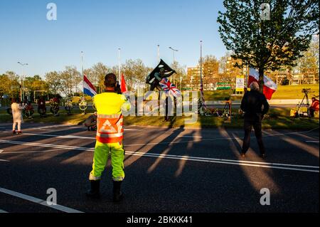 A worker is seen taking photos with a mobile phone during the ceremony.The commemorations took place at the 'Kitty de Wijze', a monument that  has become the symbol of the Jewish in Nijmegen who were deported and never come back. This year because of the current situation, the ceremony was held without an audience, just with the presence of Rabbi M. Levin and Mayor of Nijmegen Hubert Brushwood is also the chairman of the Security Council in the country. The memorial service in the Sint Stevens church was canceled this year. Stock Photo