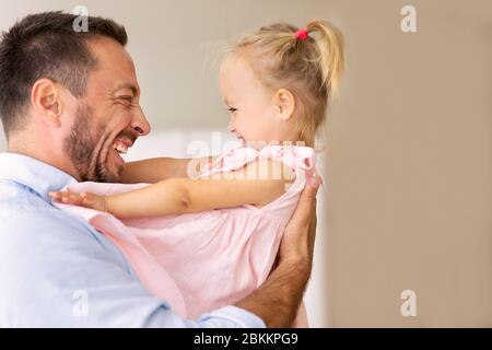 Millennial father holding his cute loving daughter Stock Photo